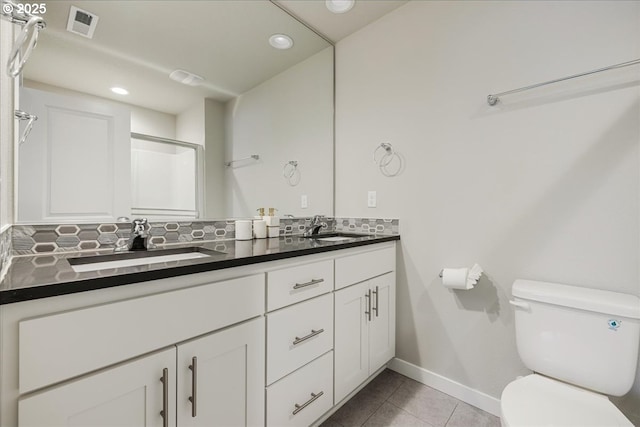 full bath featuring toilet, a sink, decorative backsplash, and tile patterned floors