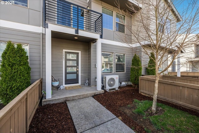 doorway to property with ac unit and fence