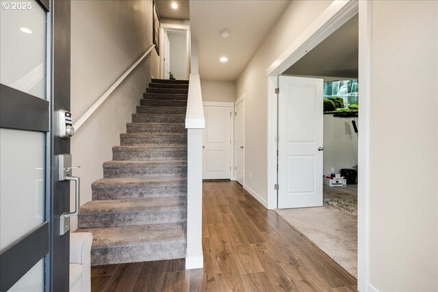 stairs with recessed lighting, baseboards, and wood finished floors