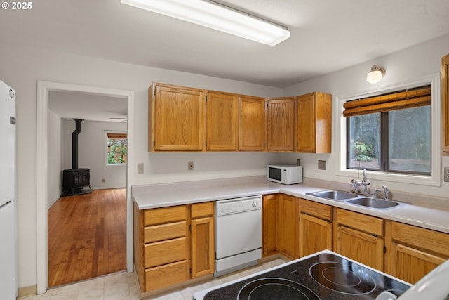 7940 SE 75th Pl, Portland, OR 97206 - kitchen with white appliances, a sink, light countertops, and a wood stove