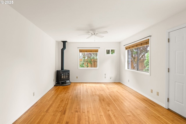7940 SE 75th Pl, Portland, OR 97206 - unfurnished living room featuring light wood finished floors, ceiling fan, a wood stove, and baseboards