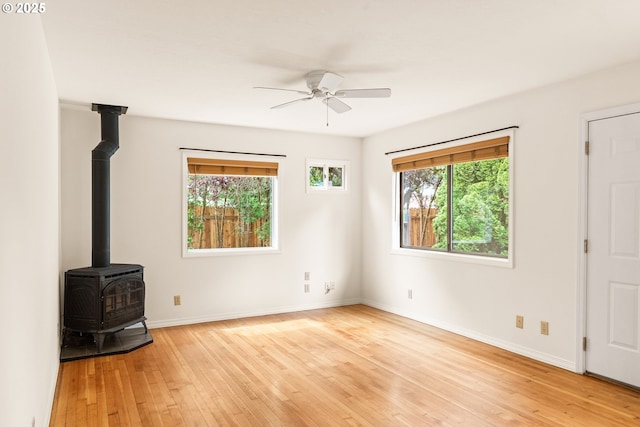 7940 SE 75th Pl, Portland, OR 97206 - unfurnished living room featuring a wood stove, plenty of natural light, and light wood-style flooring