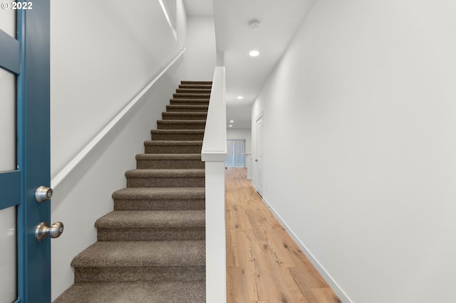 staircase featuring recessed lighting, baseboards, and wood finished floors