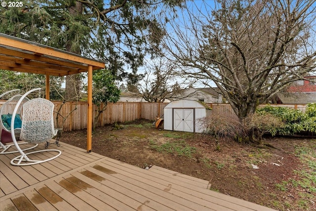 wooden terrace featuring an outbuilding, a fenced backyard, and a storage shed