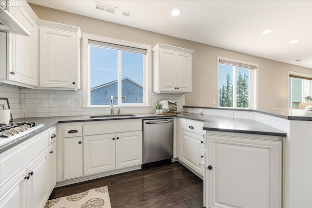 2025 De Vries Way W, Linn, OR 97068 - kitchen featuring stainless steel dishwasher, a sink, a peninsula, dark wood finished floors, and white cabinets