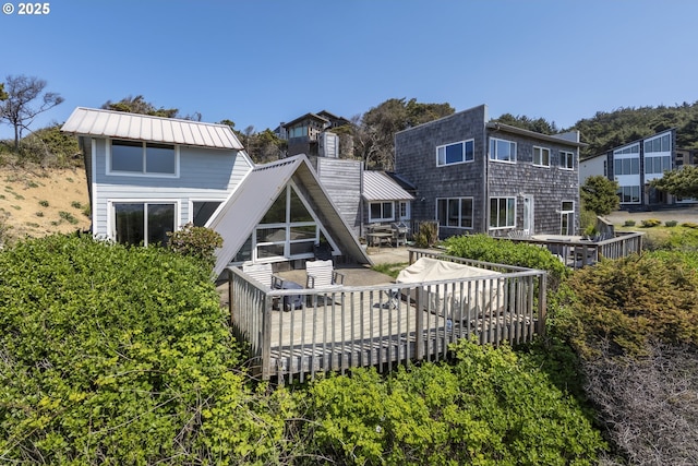 back of property with a wooden deck and metal roof