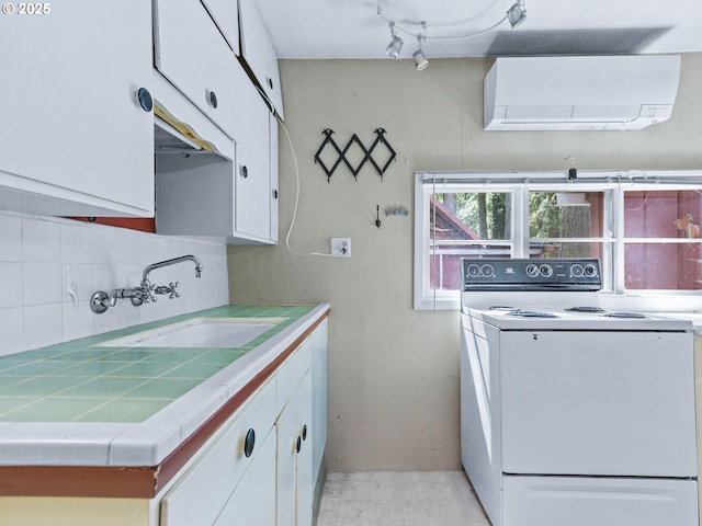 26647 E Welches Rd, Welches, OR 97067 - kitchen featuring white range with electric stovetop, a wall mounted air conditioner, tile counters, and white cabinetry
