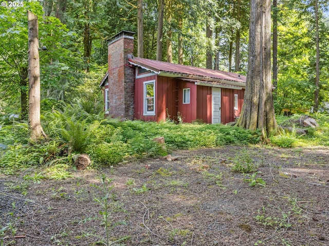 26647 E Welches Rd, Welches, OR 97067 - view of front of home featuring a chimney, a metal roof, and an outdoor structure