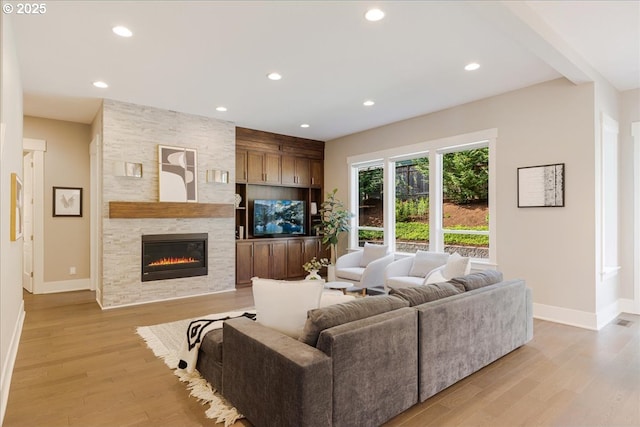 4726 SW 60th Pl, Portland, OR 97221 - living room featuring baseboards, a stone fireplace, light wood-style flooring, and recessed lighting