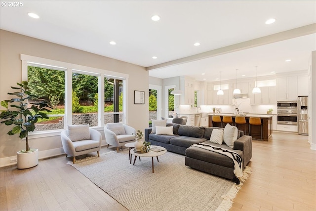 living area featuring light wood-style floors, baseboards, and recessed lighting