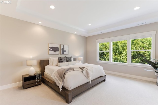 bedroom featuring visible vents, light colored carpet, baseboards, a raised ceiling, and recessed lighting