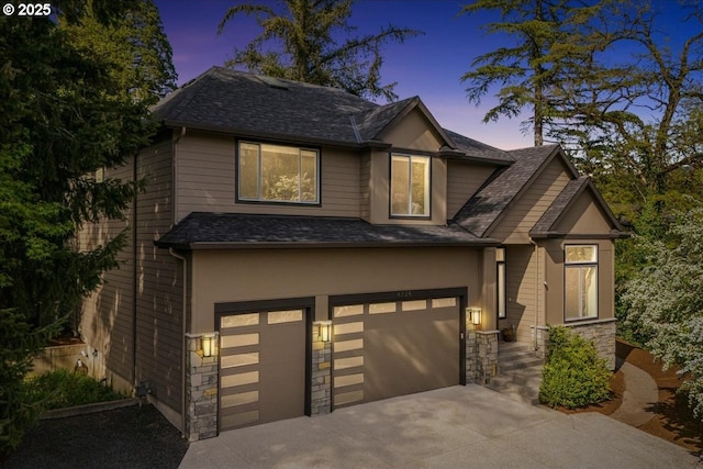 craftsman inspired home with a garage, stucco siding, stone siding, and concrete driveway