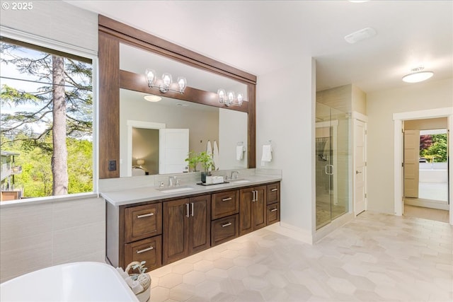 full bathroom with double vanity, a freestanding bath, a shower stall, and a sink