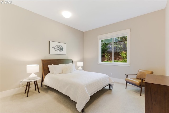 bedroom featuring light colored carpet and baseboards