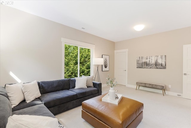living area with light colored carpet and baseboards