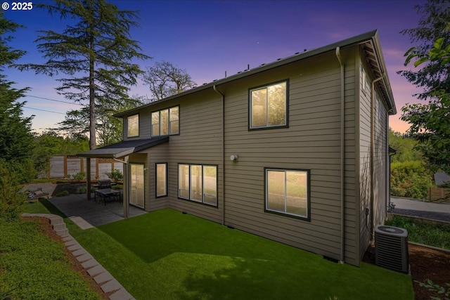 rear view of house with a patio, central AC, and a yard