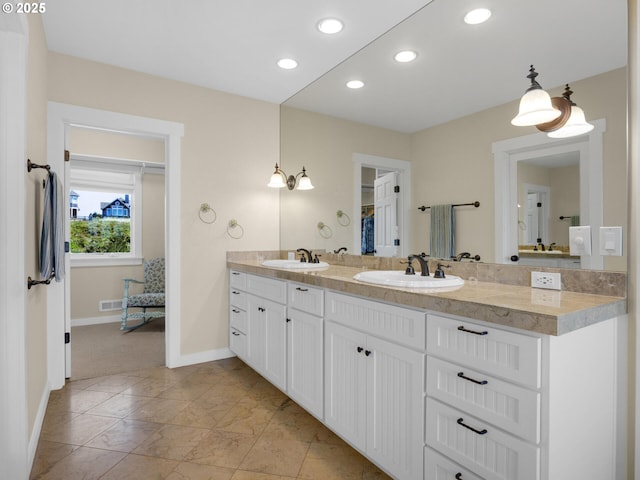 full bathroom featuring baseboards, double vanity, and recessed lighting