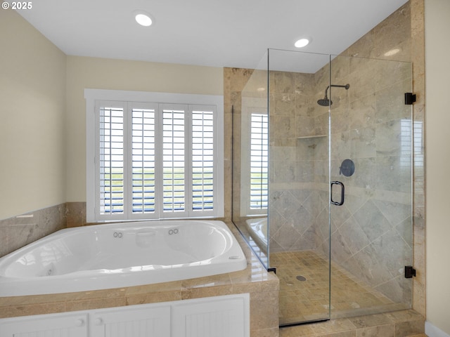 bathroom with healthy amount of natural light, a bath, a stall shower, and recessed lighting