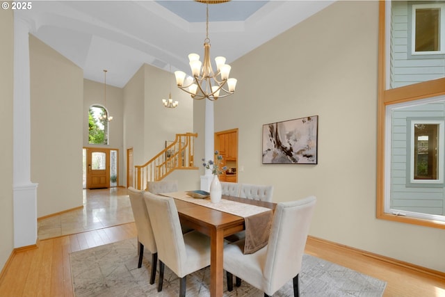 2038 Morning View Dr, Eugene, OR 97405 - dining area with a towering ceiling, a chandelier, light wood finished floors, stairs, and a raised ceiling