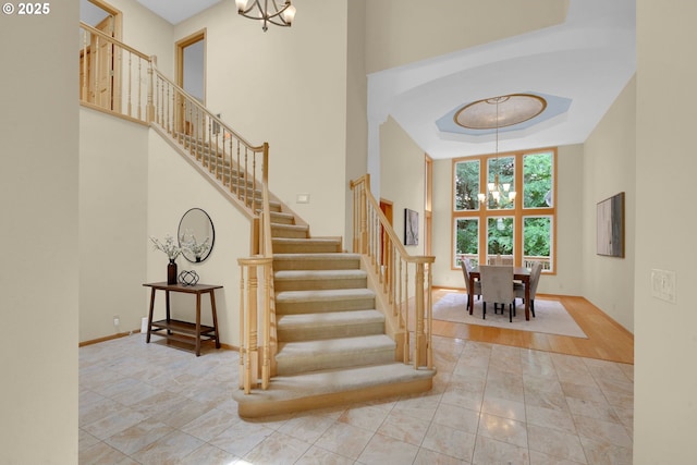 2038 Morning View Dr, Eugene, OR 97405 - stairway with a chandelier, a towering ceiling, tile patterned flooring, and arched walkways