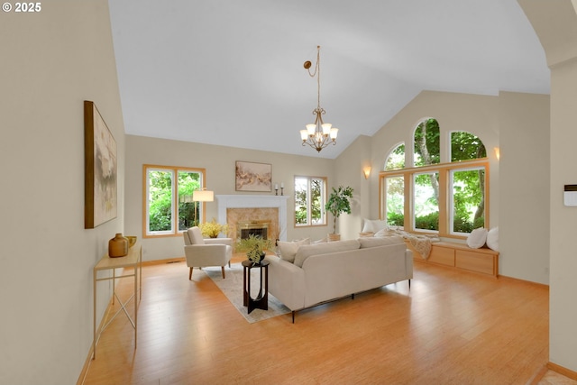 2038 Morning View Dr, Eugene, OR 97405 - living room with light wood-type flooring, a fireplace, high vaulted ceiling, and a chandelier