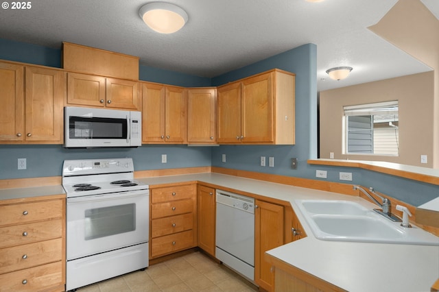 kitchen featuring white appliances, kitchen peninsula, sink, and a textured ceiling