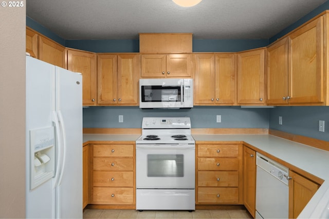 kitchen with white appliances, a textured ceiling, and light tile patterned floors