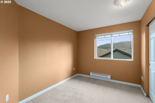 empty room with baseboard heating and light colored carpet