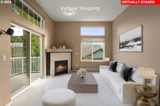 living room featuring a tiled fireplace, baseboard heating, and light colored carpet