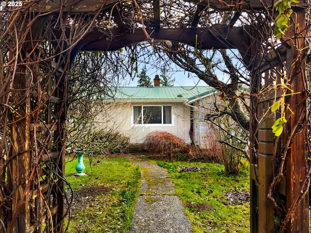 view of side of home featuring a chimney and metal roof