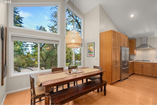 dining room featuring high vaulted ceiling, light wood finished floors, recessed lighting, and baseboards