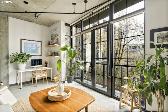 office area featuring a wall of windows, finished concrete flooring, and french doors