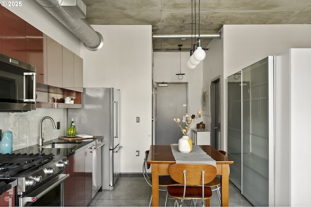 kitchen featuring a sink, decorative backsplash, appliances with stainless steel finishes, and modern cabinets