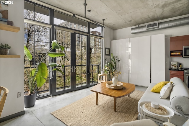 living area with visible vents, concrete flooring, and french doors