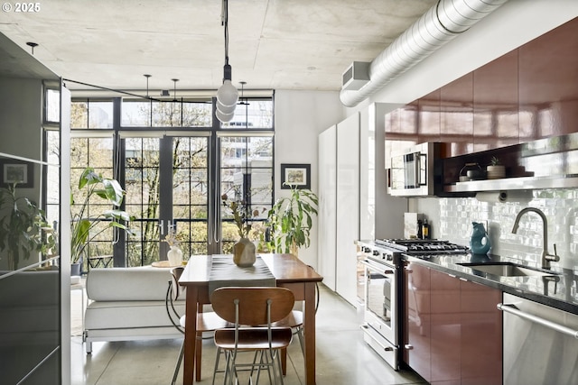 kitchen with floor to ceiling windows, stainless steel appliances, concrete flooring, and a sink