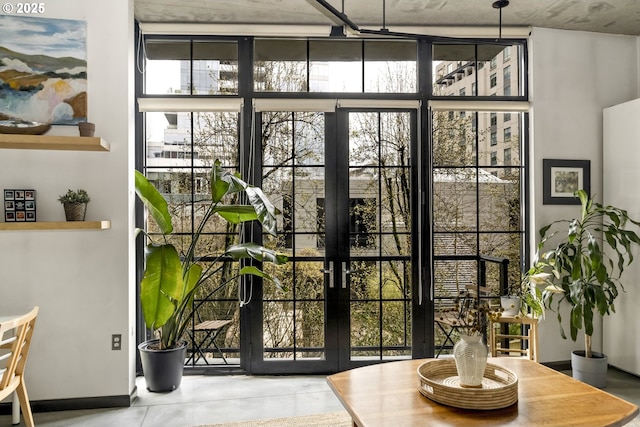 doorway to outside with floor to ceiling windows, a healthy amount of sunlight, and french doors