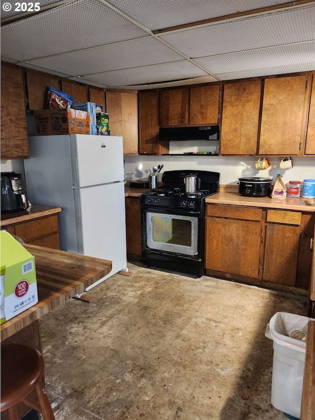 kitchen with white refrigerator and black gas range oven