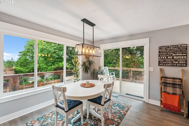 dining space featuring wood finished floors and baseboards