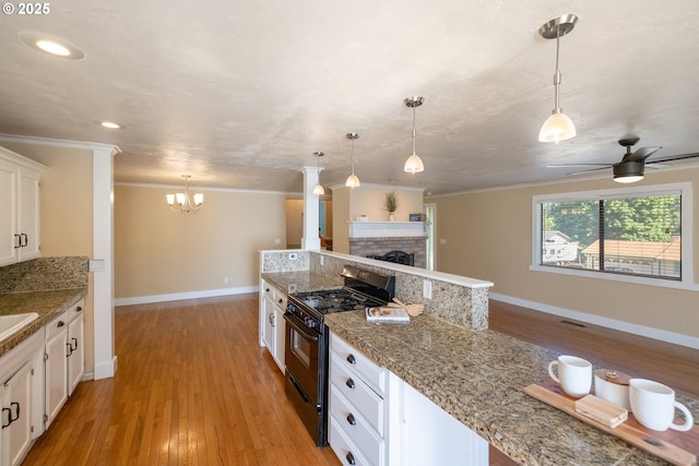 1221 SW Maple St, Dallas, OR 97338 - kitchen featuring black gas stove, crown molding, light wood-type flooring, white cabinets, and a fireplace