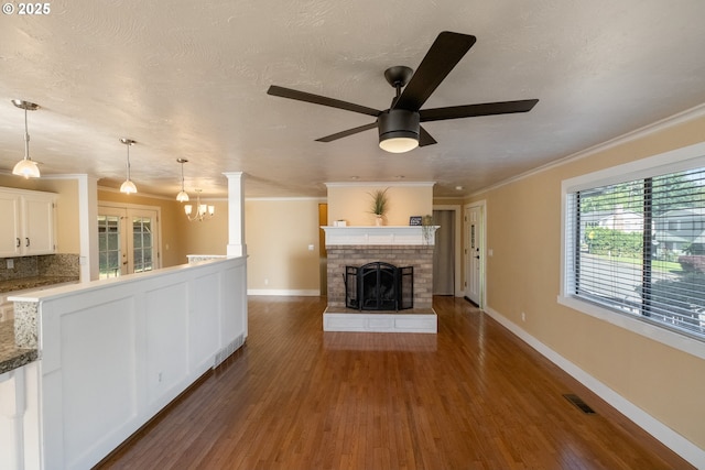 1221 SW Maple St, Dallas, OR 97338 - unfurnished living room featuring ceiling fan, crown molding, wood finished floors, a chandelier, and a fireplace