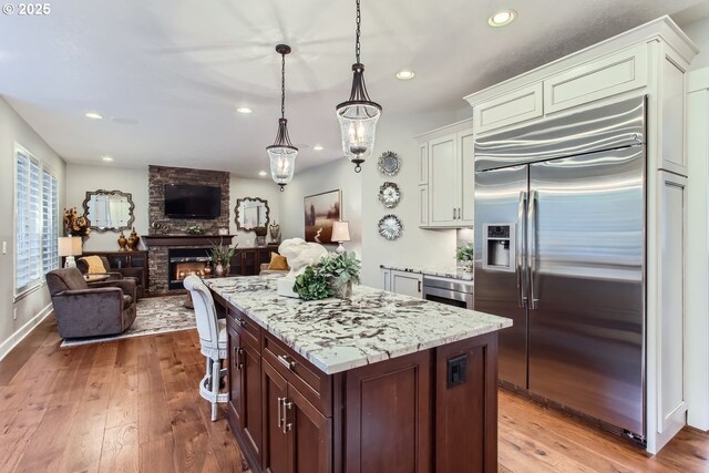 kitchen featuring light stone counters, double oven range, backsplash, and custom exhaust hood