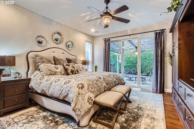 bedroom featuring multiple windows, wood-type flooring, access to outside, and ceiling fan