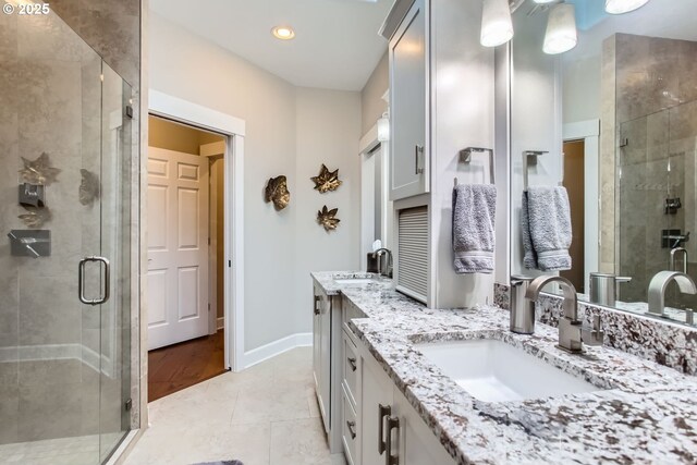 bathroom featuring an enclosed shower, vanity, a skylight, and tile patterned flooring