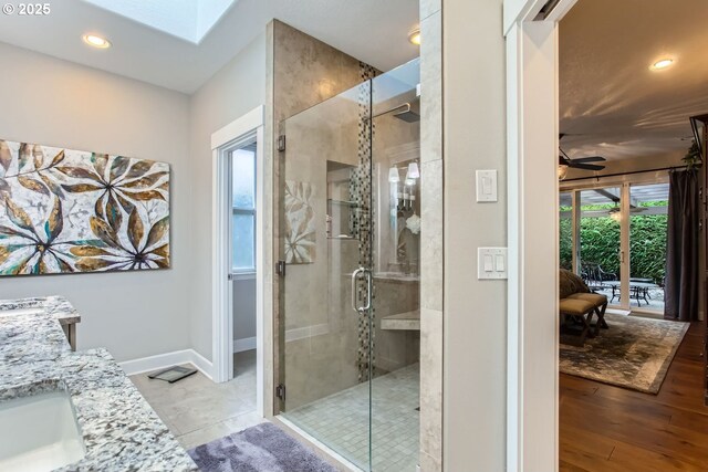 bathroom with a shower with shower door, vanity, and tile patterned flooring