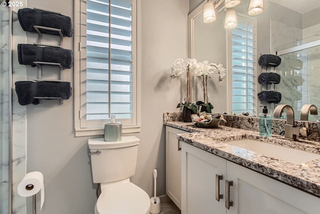 bathroom with vanity, toilet, and an enclosed shower