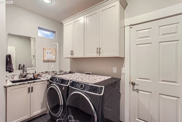 washroom featuring cabinets, washer and clothes dryer, dark tile patterned floors, and sink