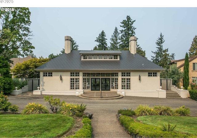 rear view of property with a patio, a lawn, and french doors