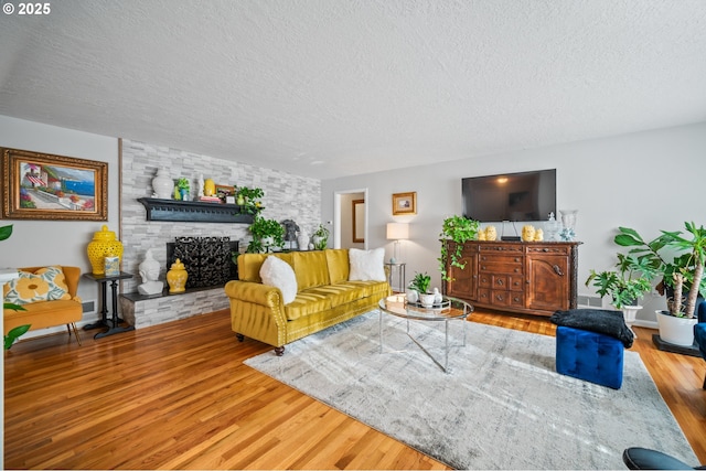 living room with hardwood / wood-style flooring, a fireplace, and a textured ceiling