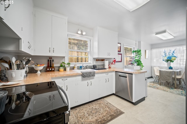 kitchen featuring white cabinetry, stainless steel dishwasher, and range