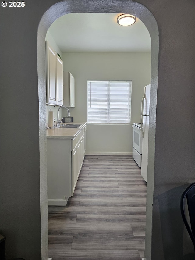617 SW 3rd St, Pendleton, OR 97801 - kitchen with a sink, arched walkways, white appliances, white cabinetry, and a textured wall